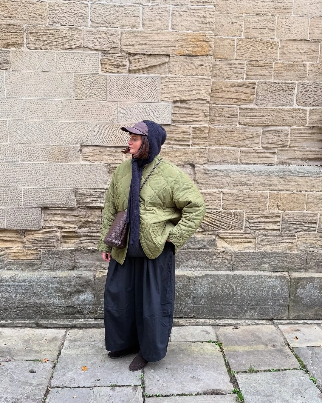 Olive quilted jacket with dark wide skirt and navy cap