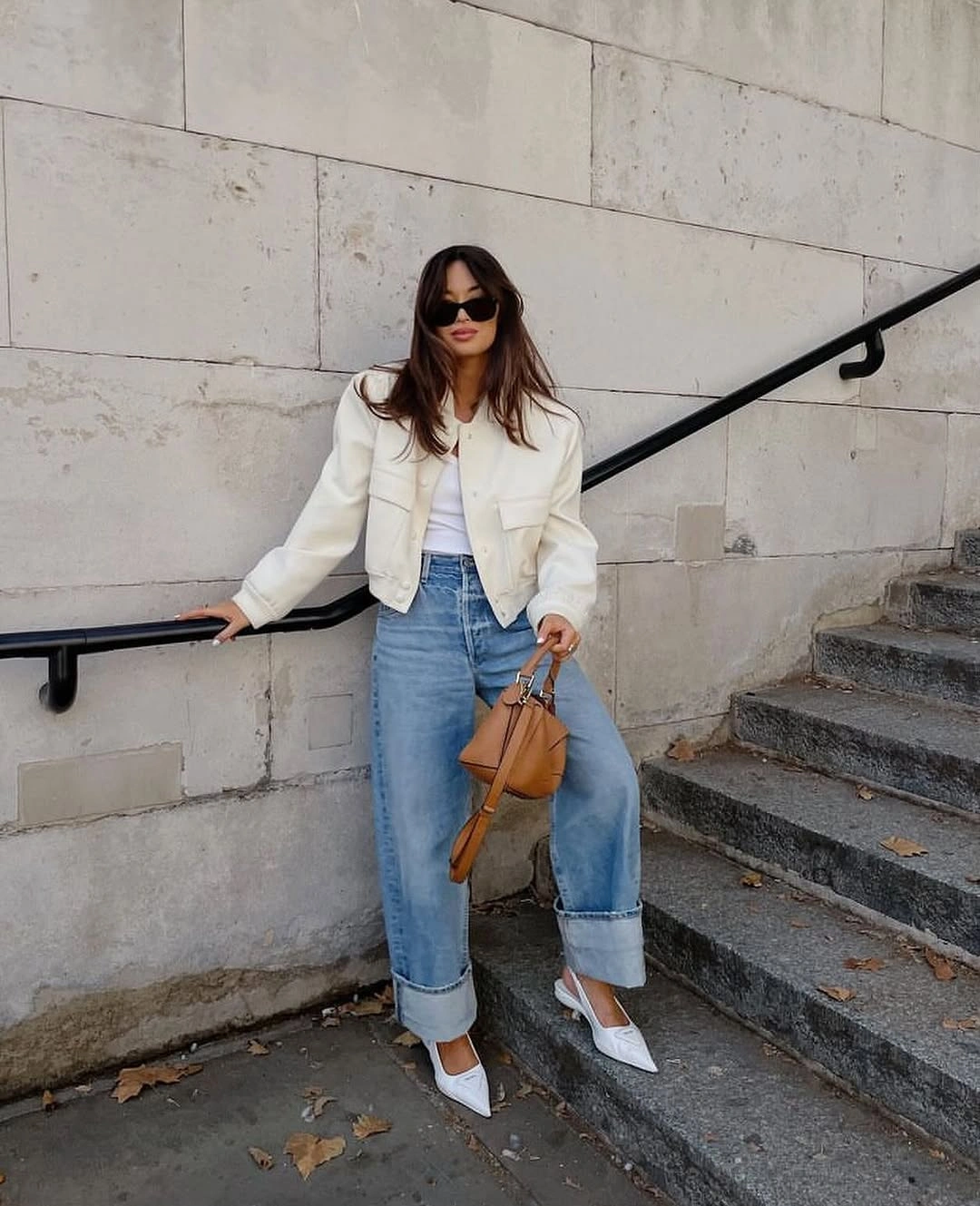 Ivory cropped jacket with cuffed blue jeans pointed shoes and tan bag