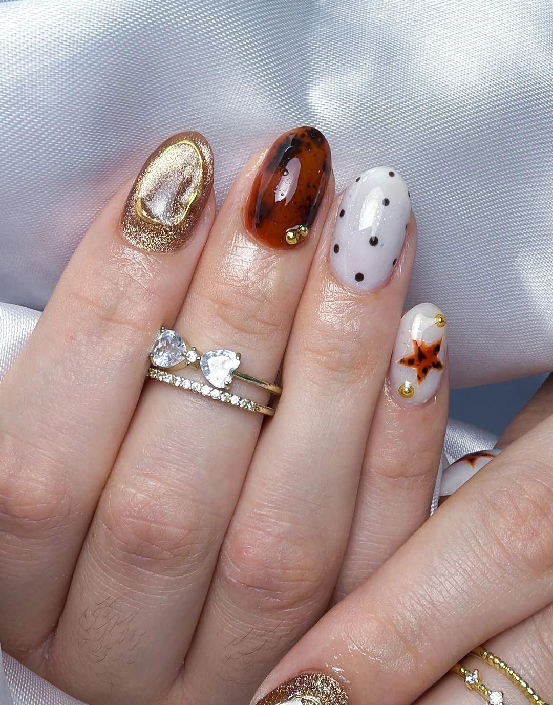 Short mixed warm nails with black dots brown pattern and orange accent