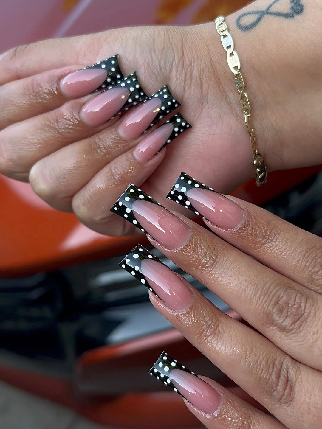 Long nude square nails with black tips and white dotted arcs