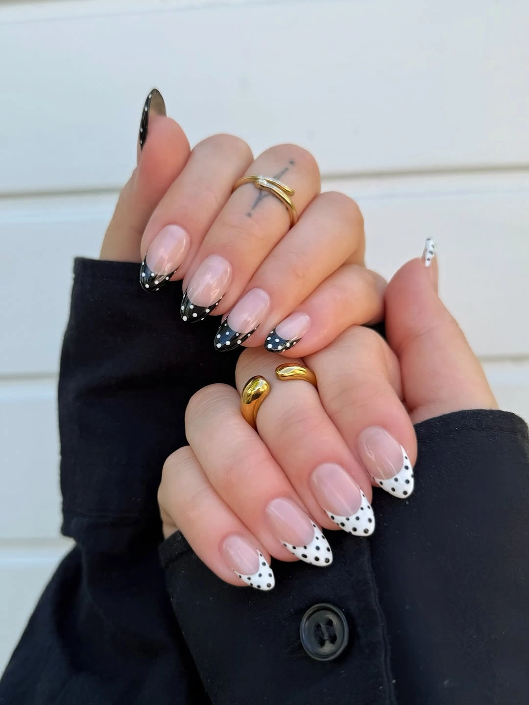 Nude almond nails with white tips and small black polka dots