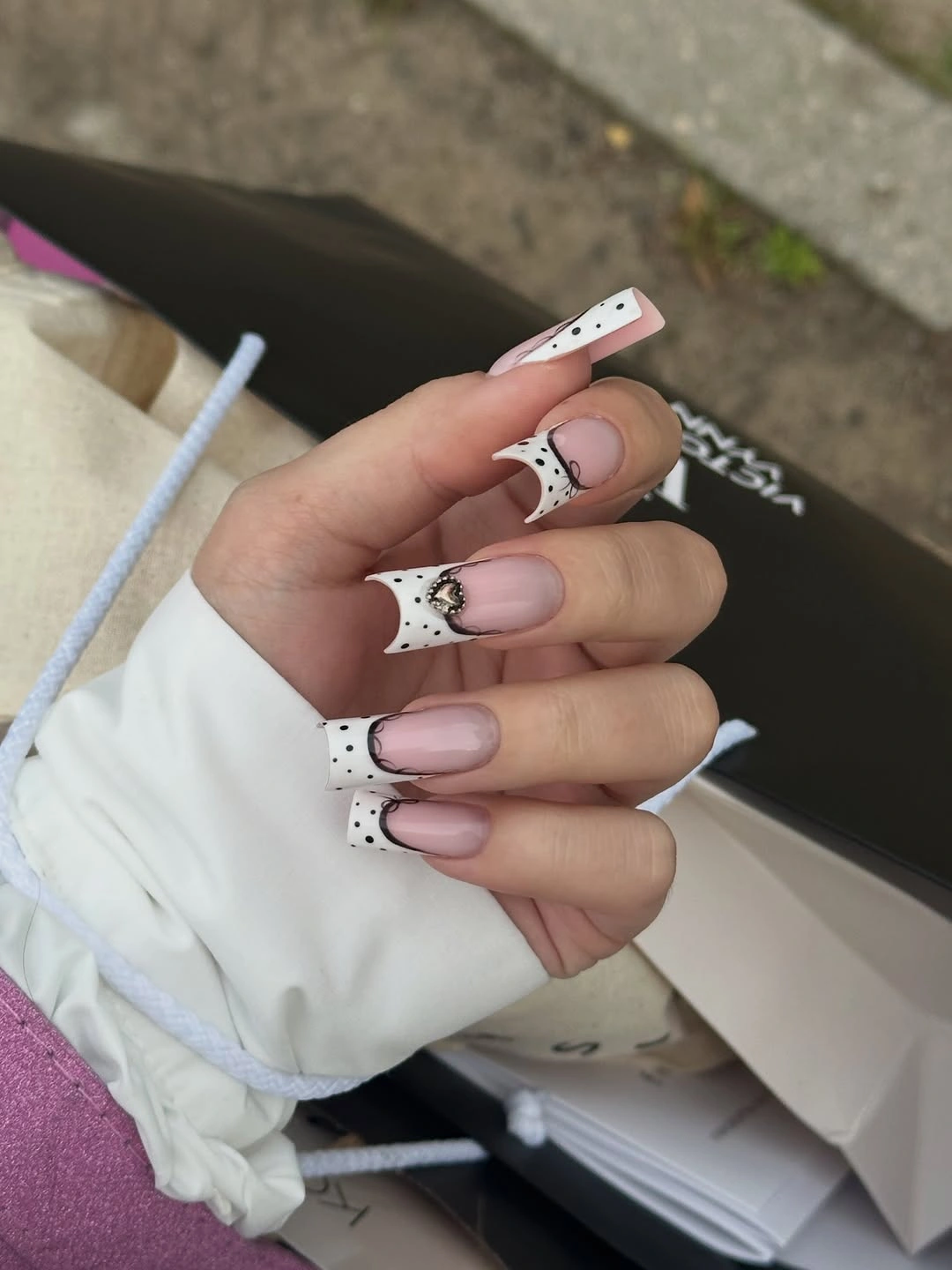 Long nude square nails with white tip panels and black dots