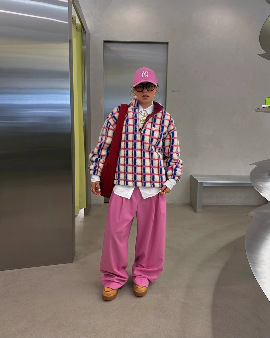 Checked jacket with bright pink wide trousers and cap