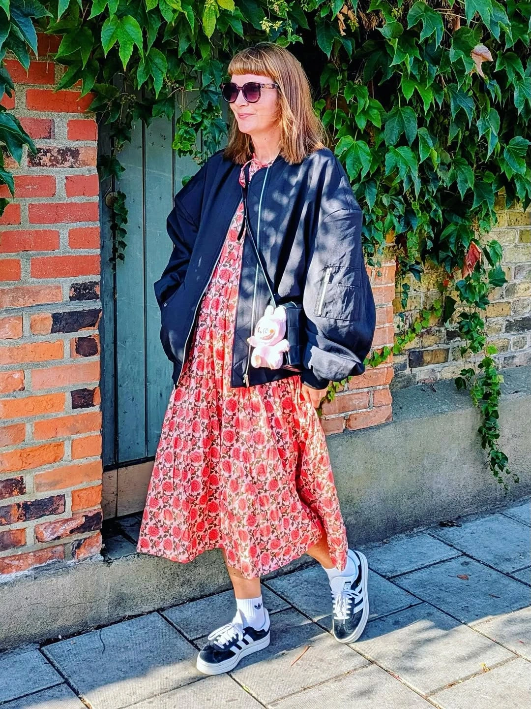 Navy bomber over red floral midi dress and sneakers