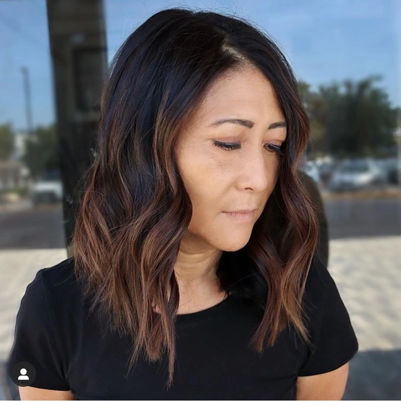Shoulder length brunette waves with a side part