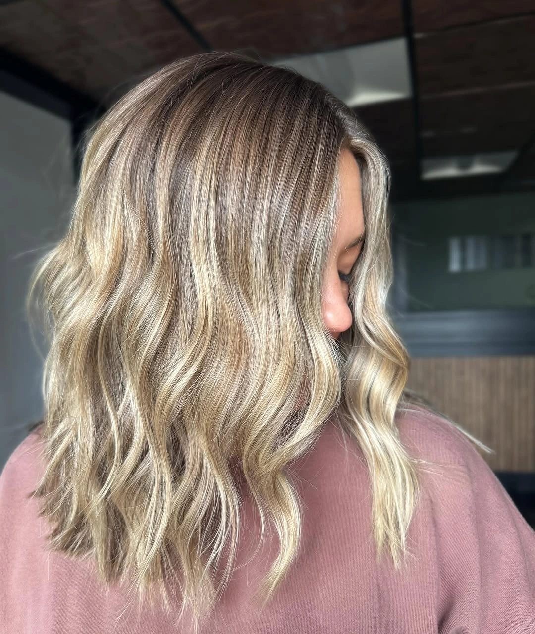 Rooted blonde shoulder length waves with side part