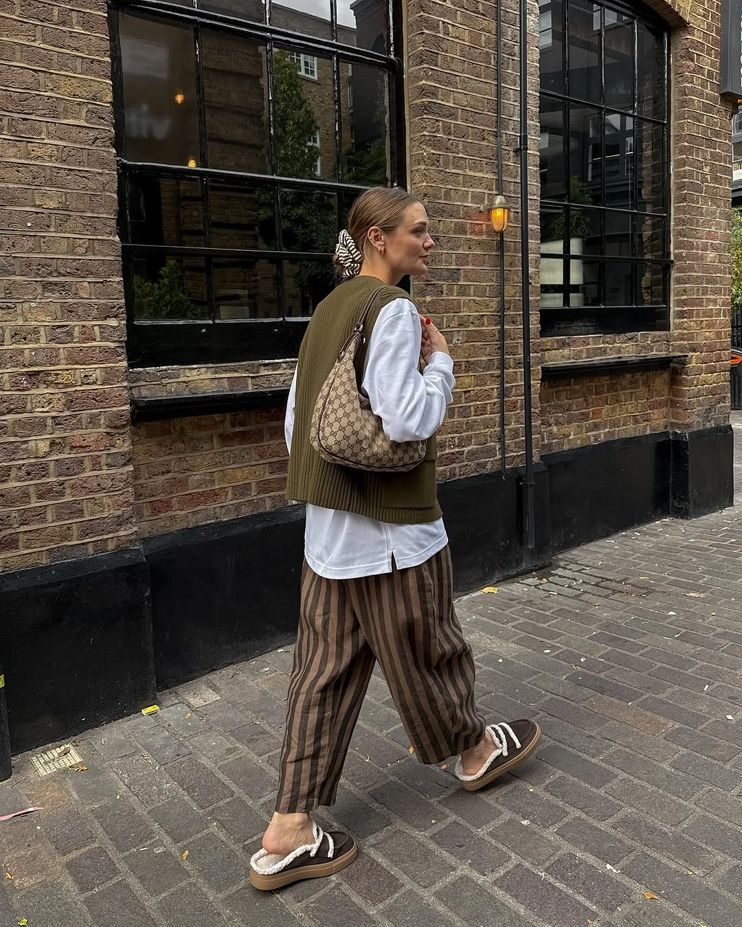 White shirt and brown vest with striped wide trousers