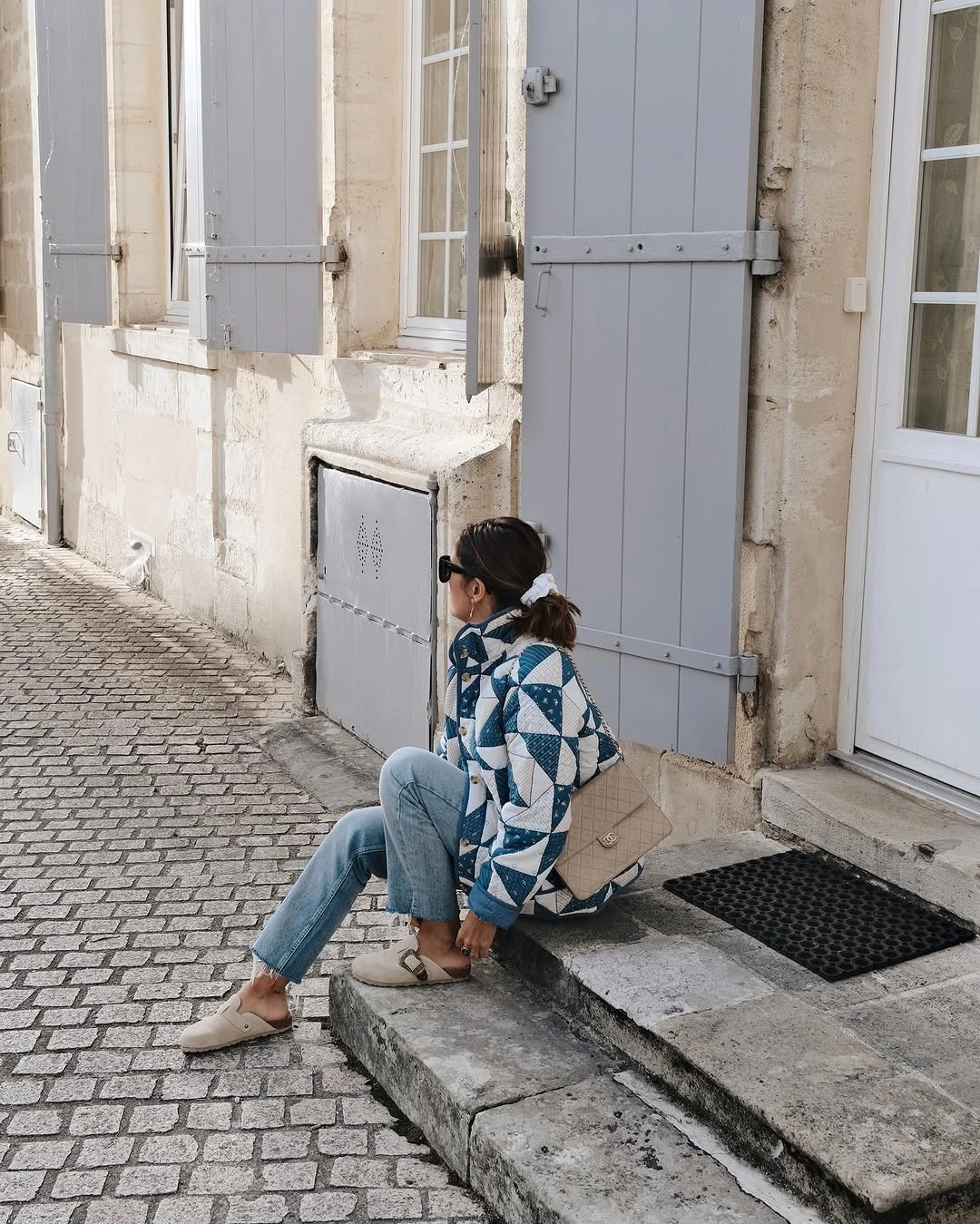 Blue patterned layer with pale jeans and white sneakers