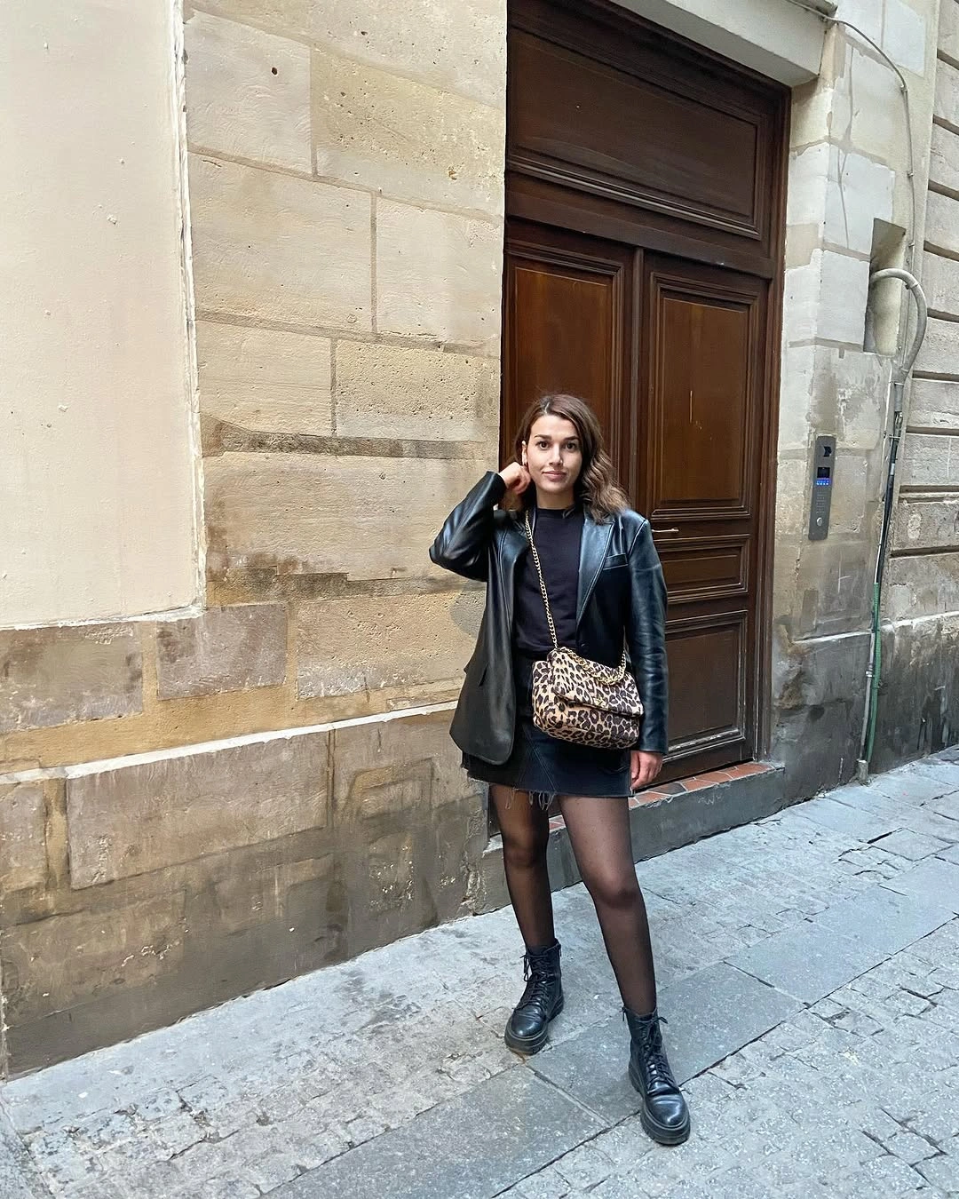 Black jacket tights chunky boots and patterned bag