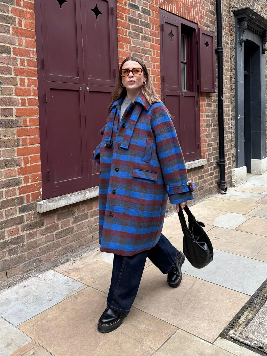 Oversized blue burgundy plaid coat with dark trousers