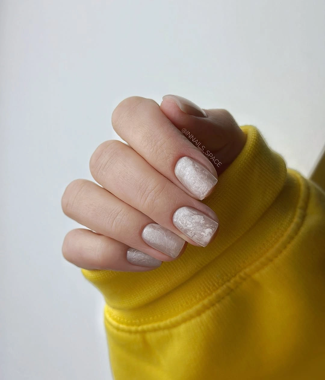 short milky white nails with pearly shine and tiny warm flecks