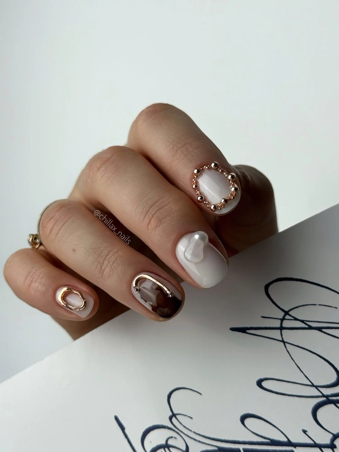 short pale nails with taupe French tips and tiny gold accents