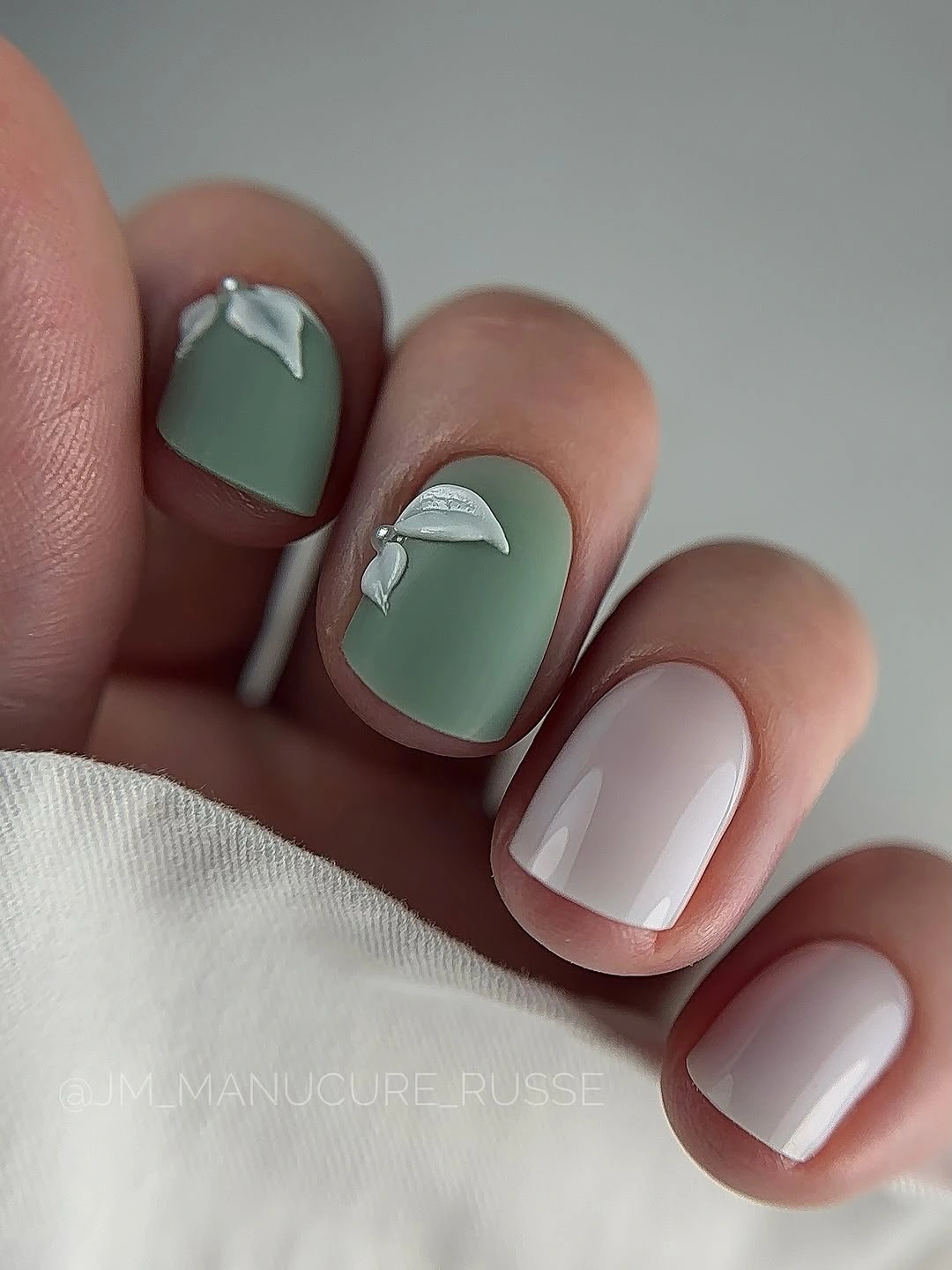 short sage green and milky white nails with pale floral accents