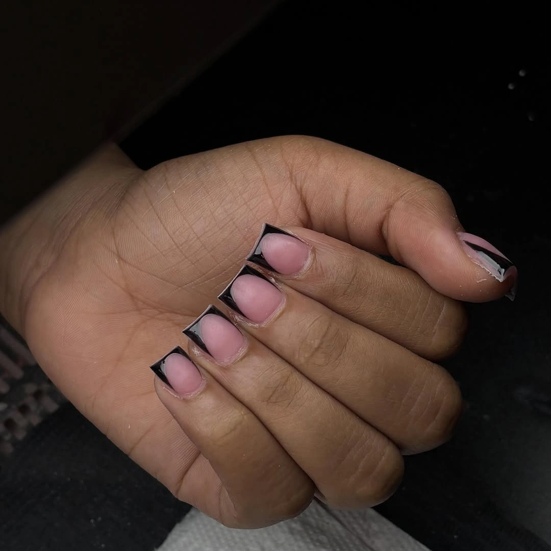 short pink nude nails with crisp black French tips
