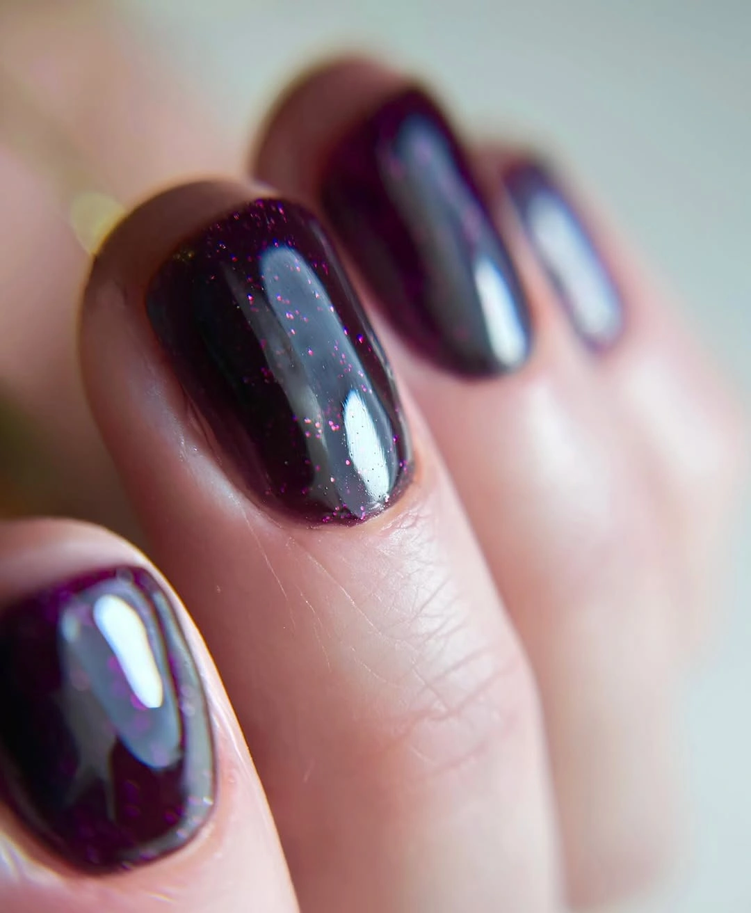 short rounded plum nails with blue violet reflective shine