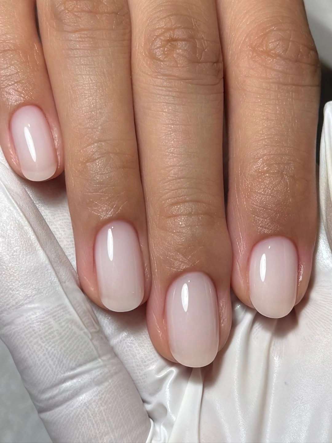 short oval nails with a plain glossy milky white finish