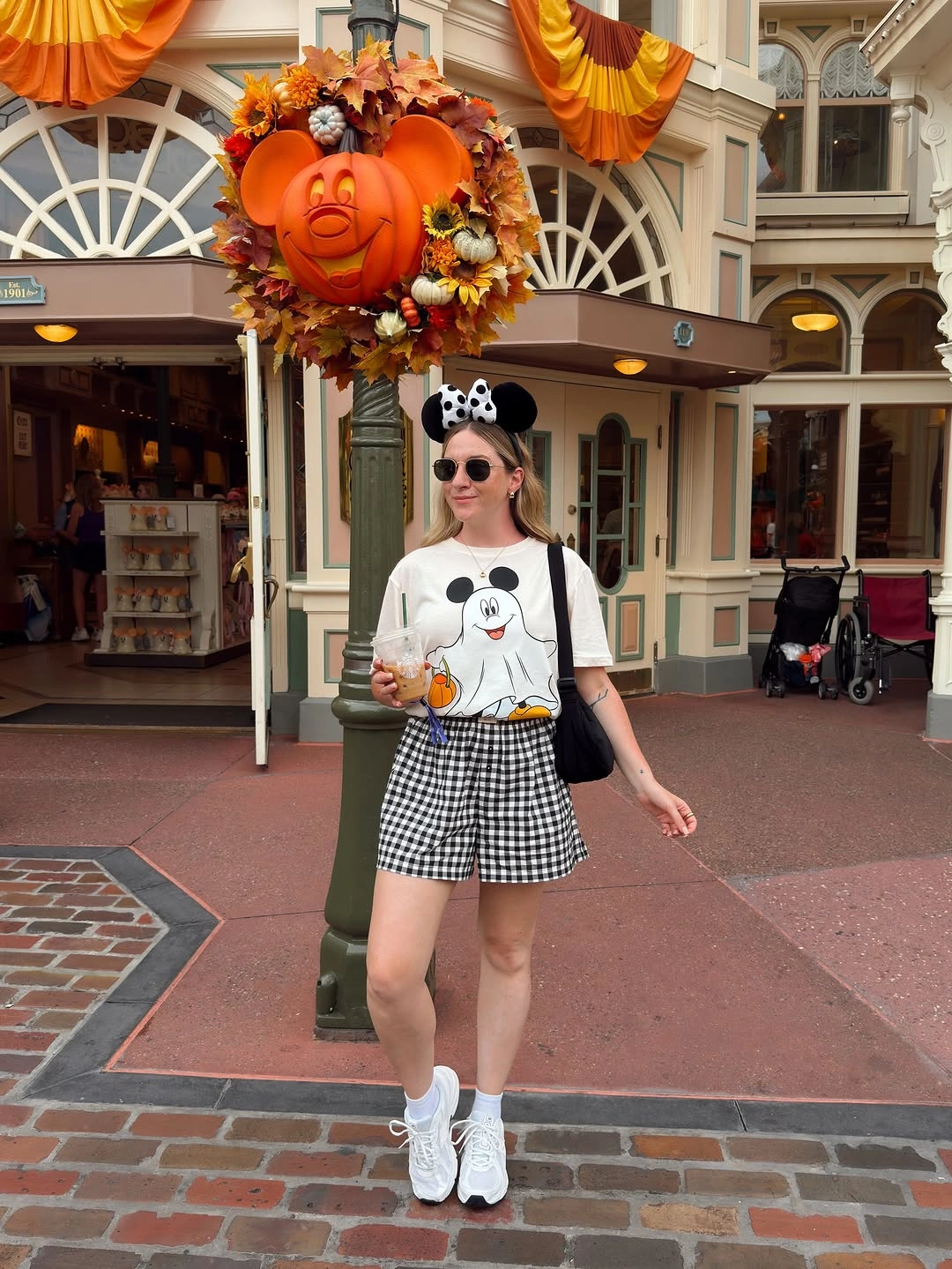 White graphic T-shirt with black-and-white gingham shorts sneakers and round-ear headband