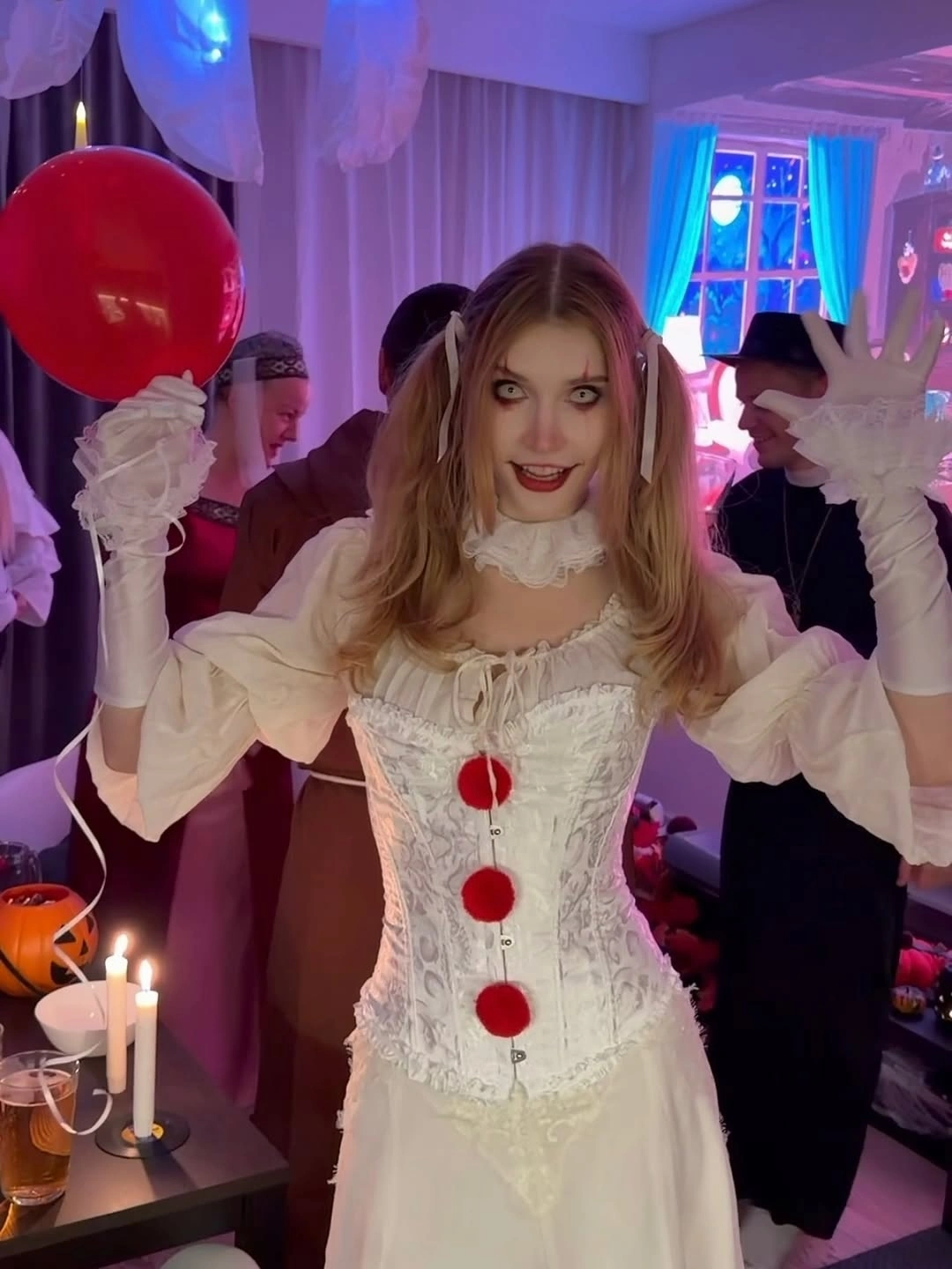 White ruffled corset-style clown dress with three red pom-poms white gloves and red balloon