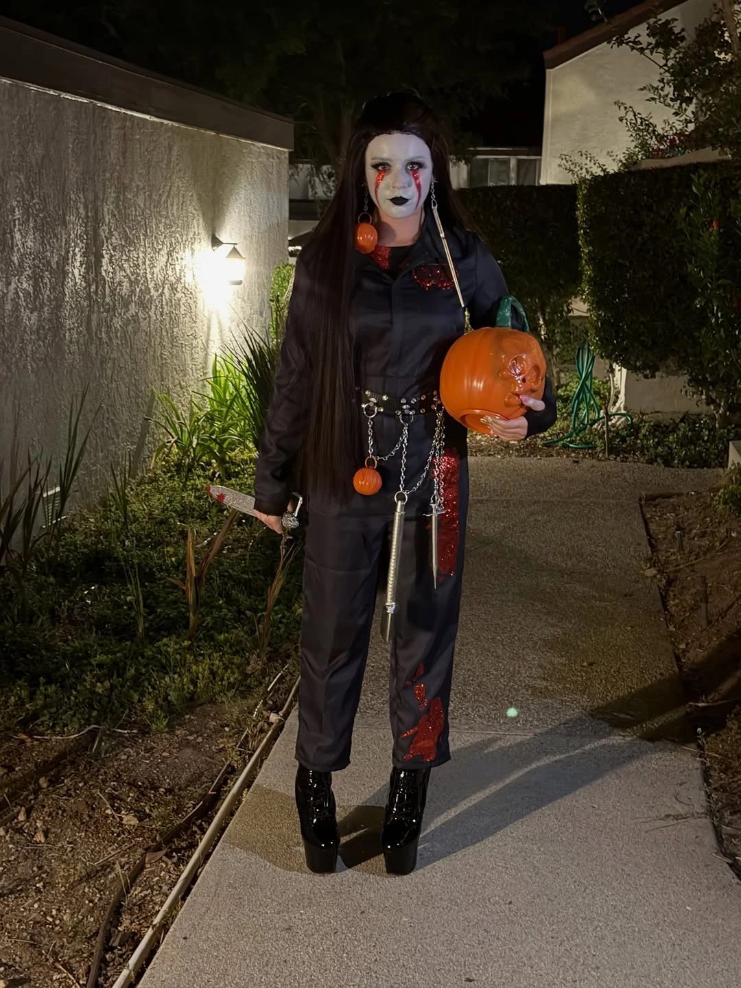 Dark utility jumpsuit with chain belt orange pumpkin bag and ankle boots