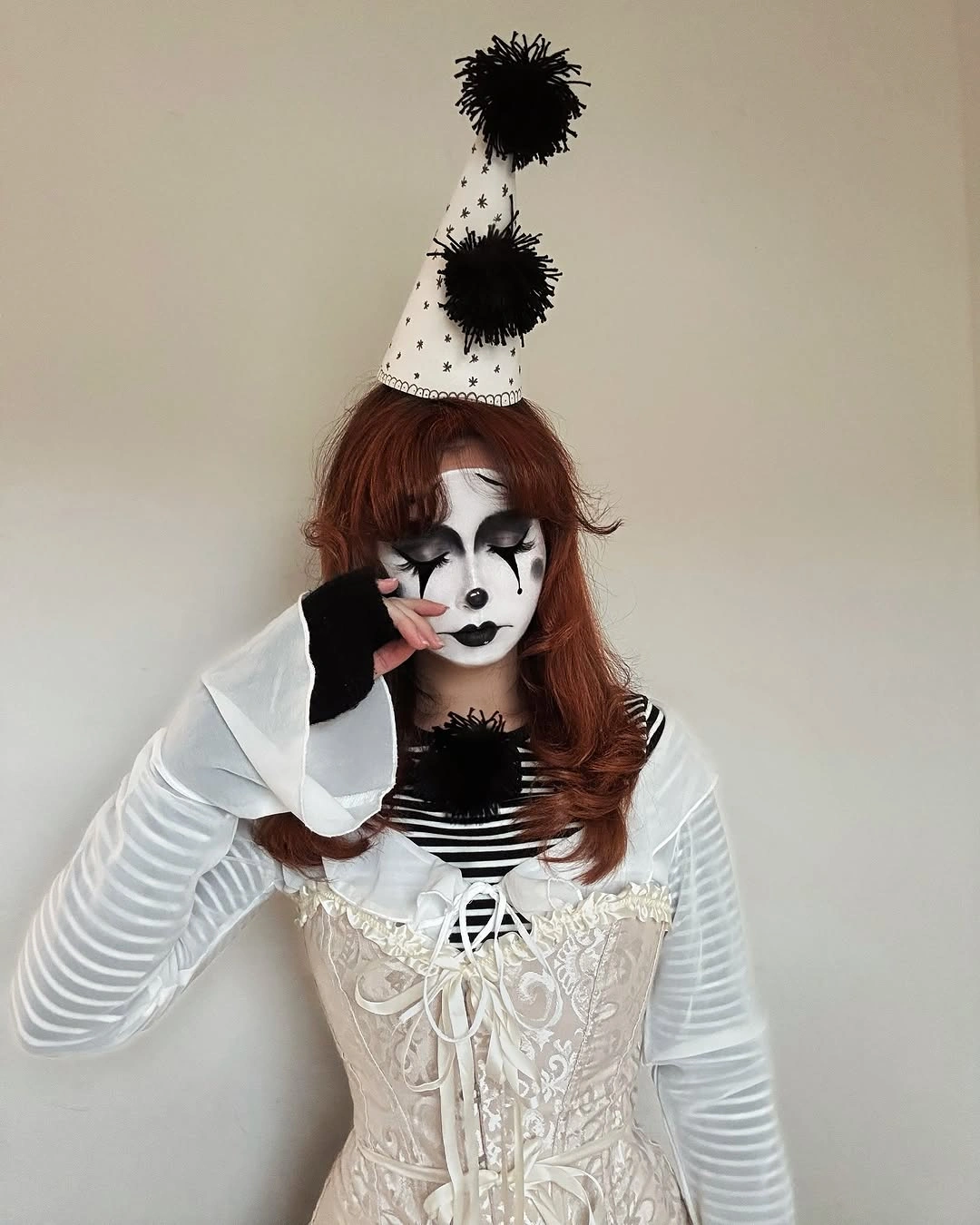 White corset-style costume with striped sleeves ruffled collar and black boots