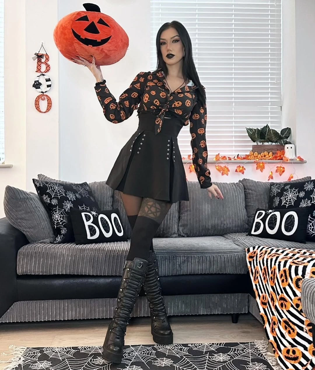 Orange print blouse with black mini skirt tights and lace-up boots
