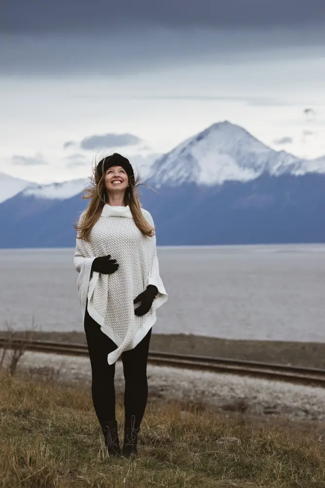 White Knit Poncho Over Black Base Layers for Versatile Travel — Winter Travel Outfits