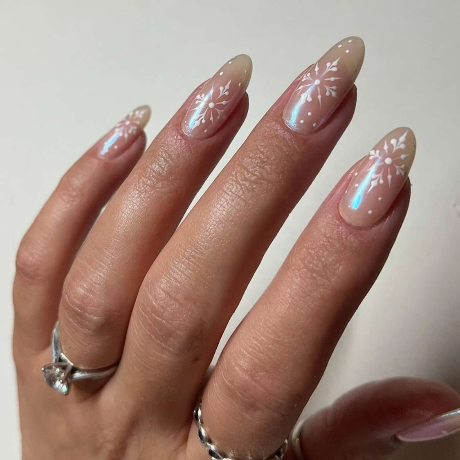 Iridescent Nude Almond Nails with Snowflakes Iridescent Nude Almond Nails with Snowflakes — Winter Nail Colors for Women Over 40
