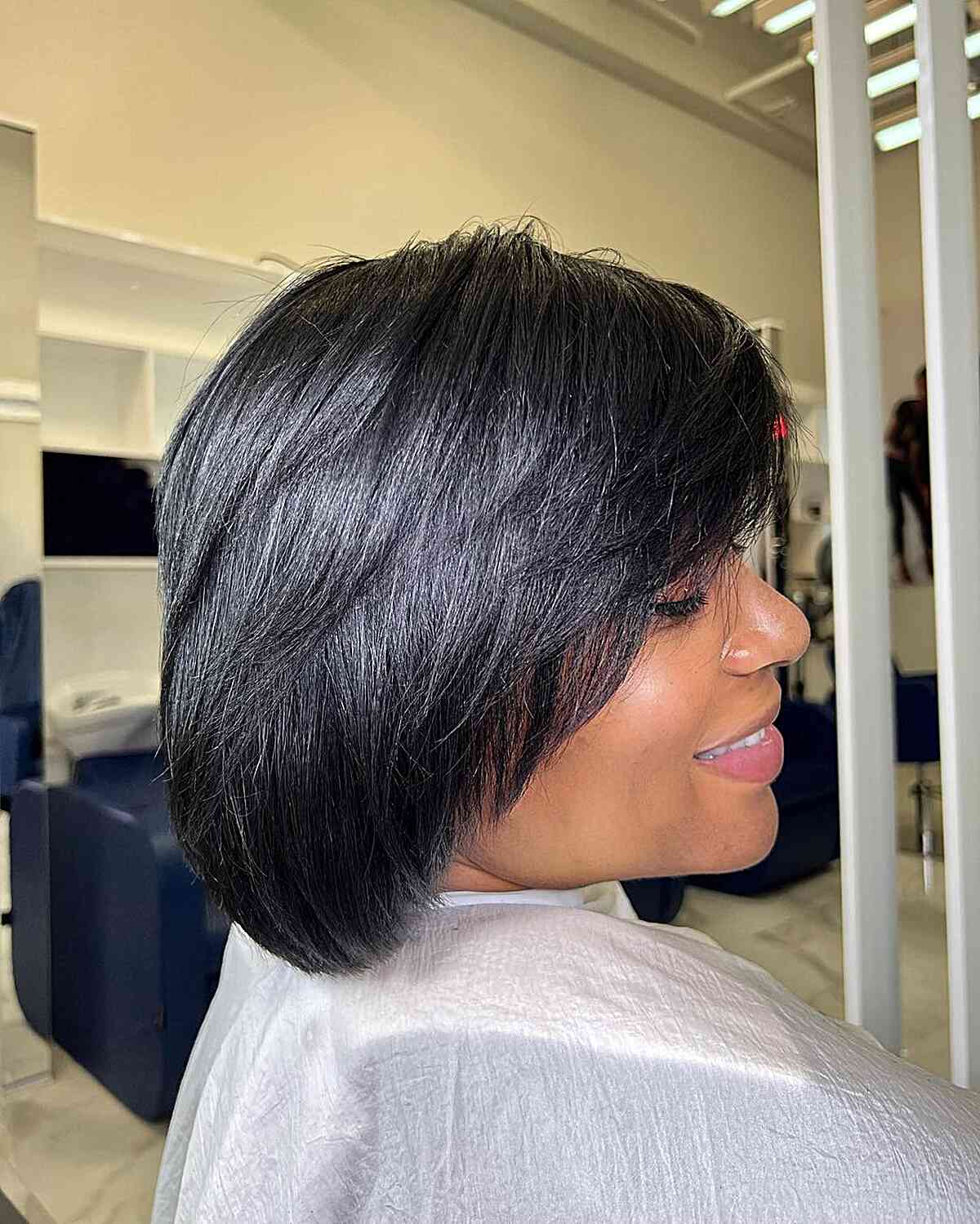 Collarbone-Length Feathered Layered Bob With Side Bangs Collarbone-Length Feathered Layered Bob With Side Bangs — Winter Haircuts for Black Women