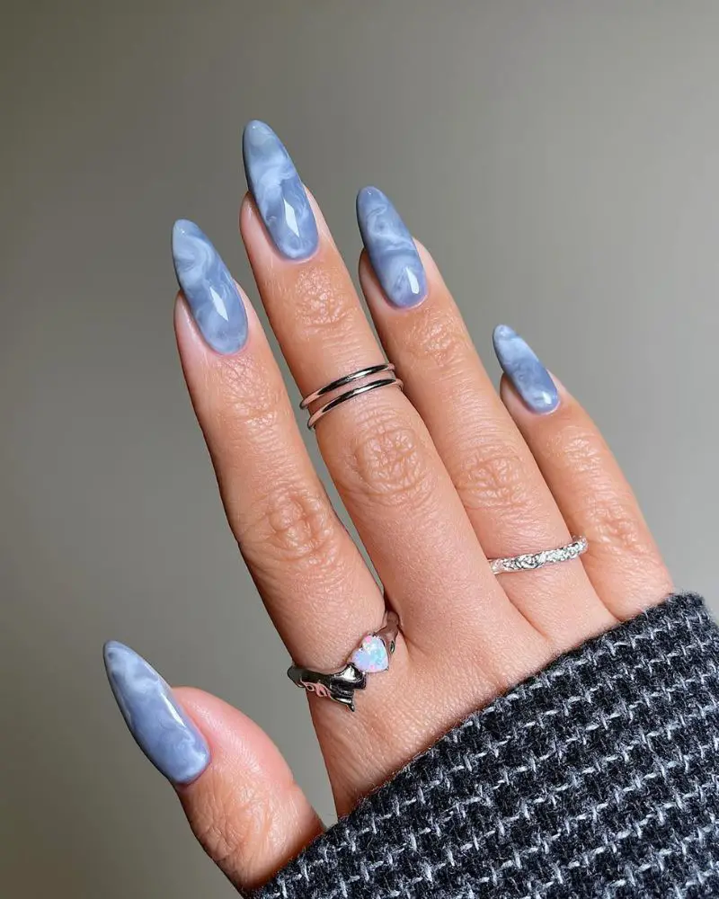 Blue White Marble Swirl Stilettos — The Hand Is Adorned With Silver Rings — Winter Marble Nails