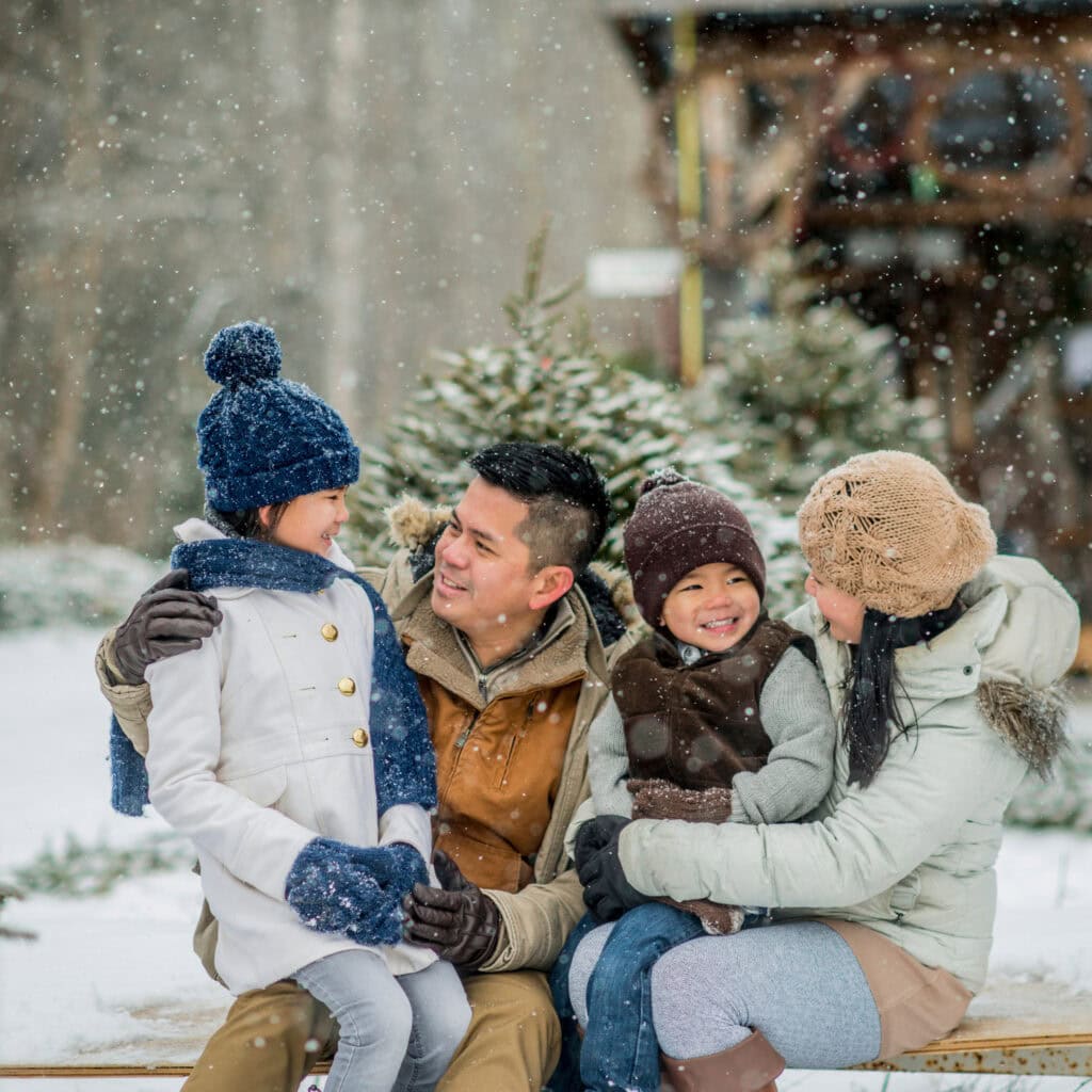 Winter Family Photo with Puffer Coats and Knit Hats in Snow — Winter Family Photo Outfits
