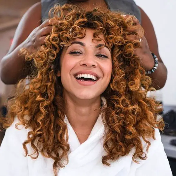 Collarbone Curly Copper Base With Blonde Highlights Collarbone Curly Copper Base With Blonde Highlights — Winter Hair Colors for Curly Hair