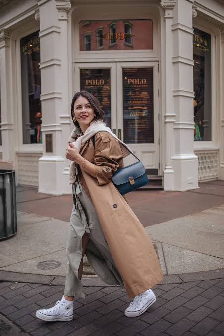 Long Tan Trench Coat Over Grey Trousers and Sneakers Long Tan Trench Coat Over Grey Trousers and Sneakers — Winter to Spring Transition Outfits