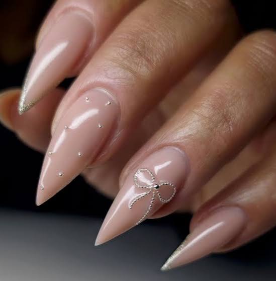 Sheer Nude Stilettos With Silver Glitter and Bow Art Sheer Nude Stilettos With Silver Glitter and Bow Art — Neutral Nail Colors