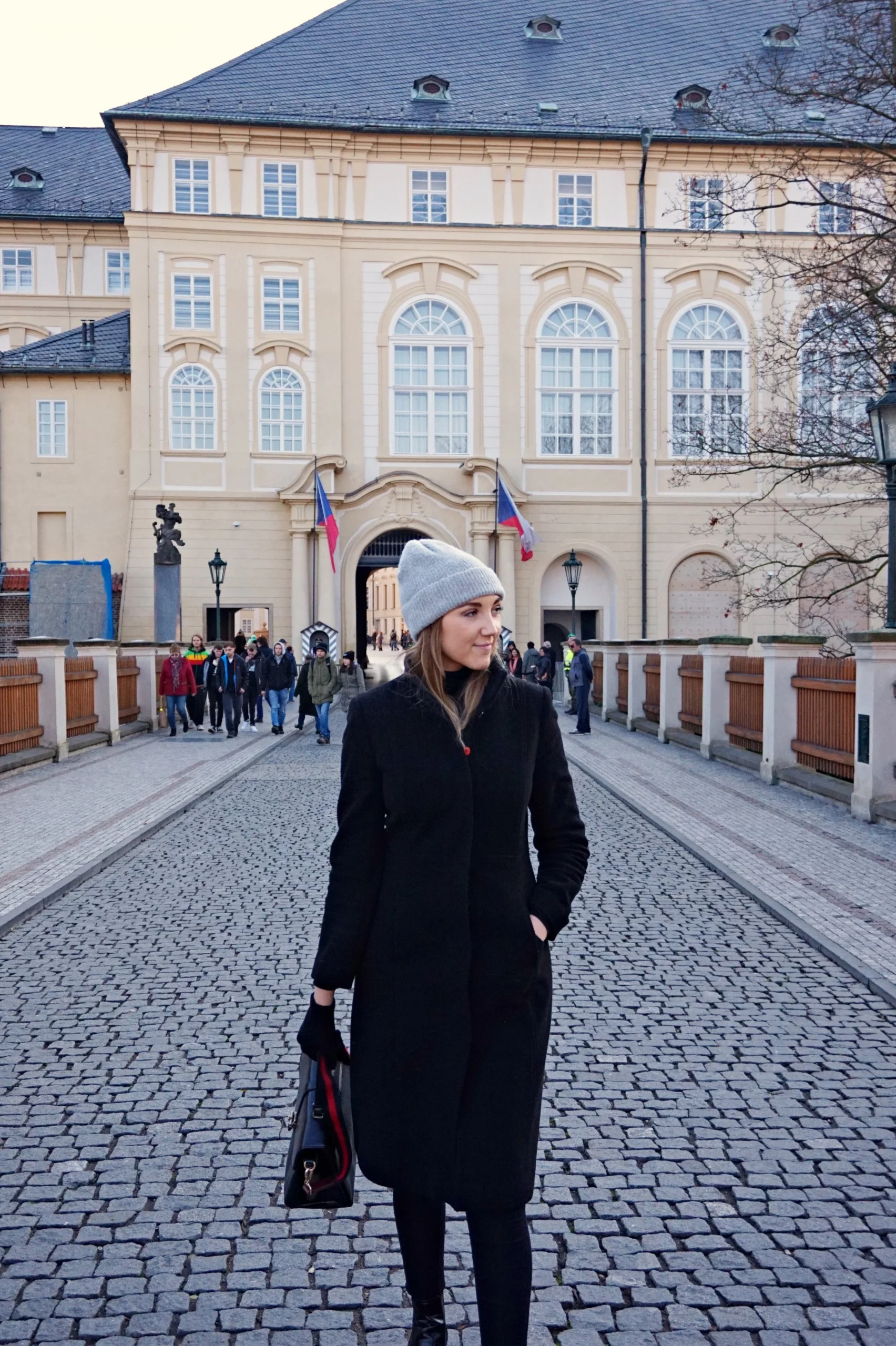 Long Black Wool Coat Over Dress and Trousers for Elegant Travel — Winter Travel Outfits