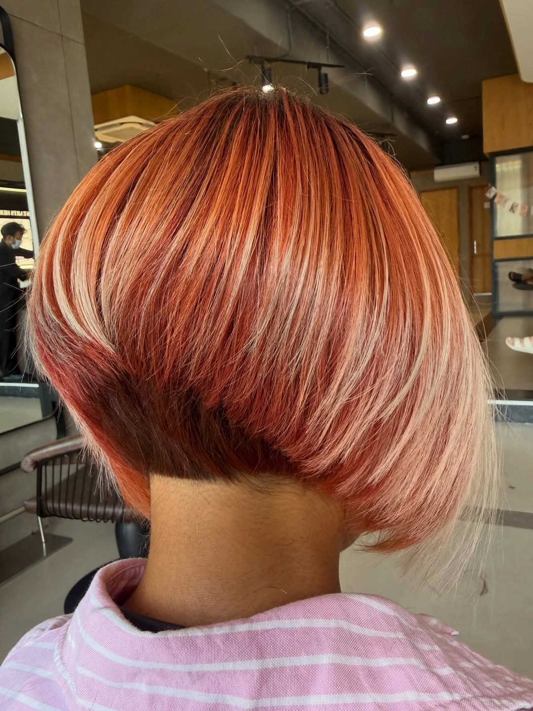 Copper red short bob with exposed nape and pale side ribbons