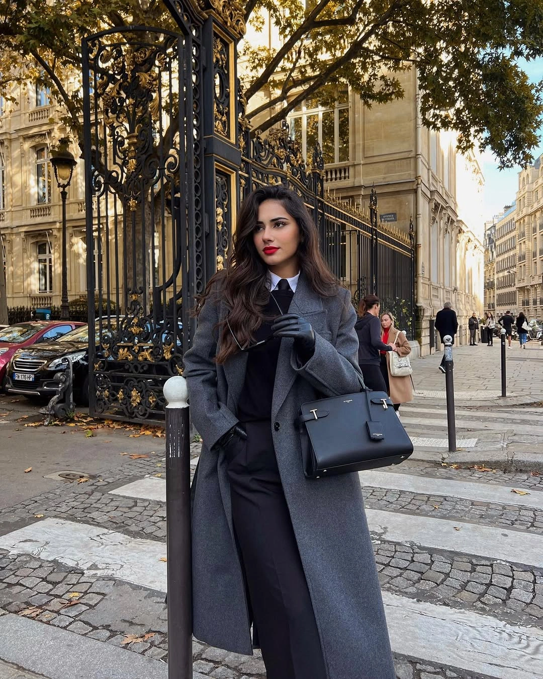 Deep navy long coat matching wide trousers black top and structured black handbag