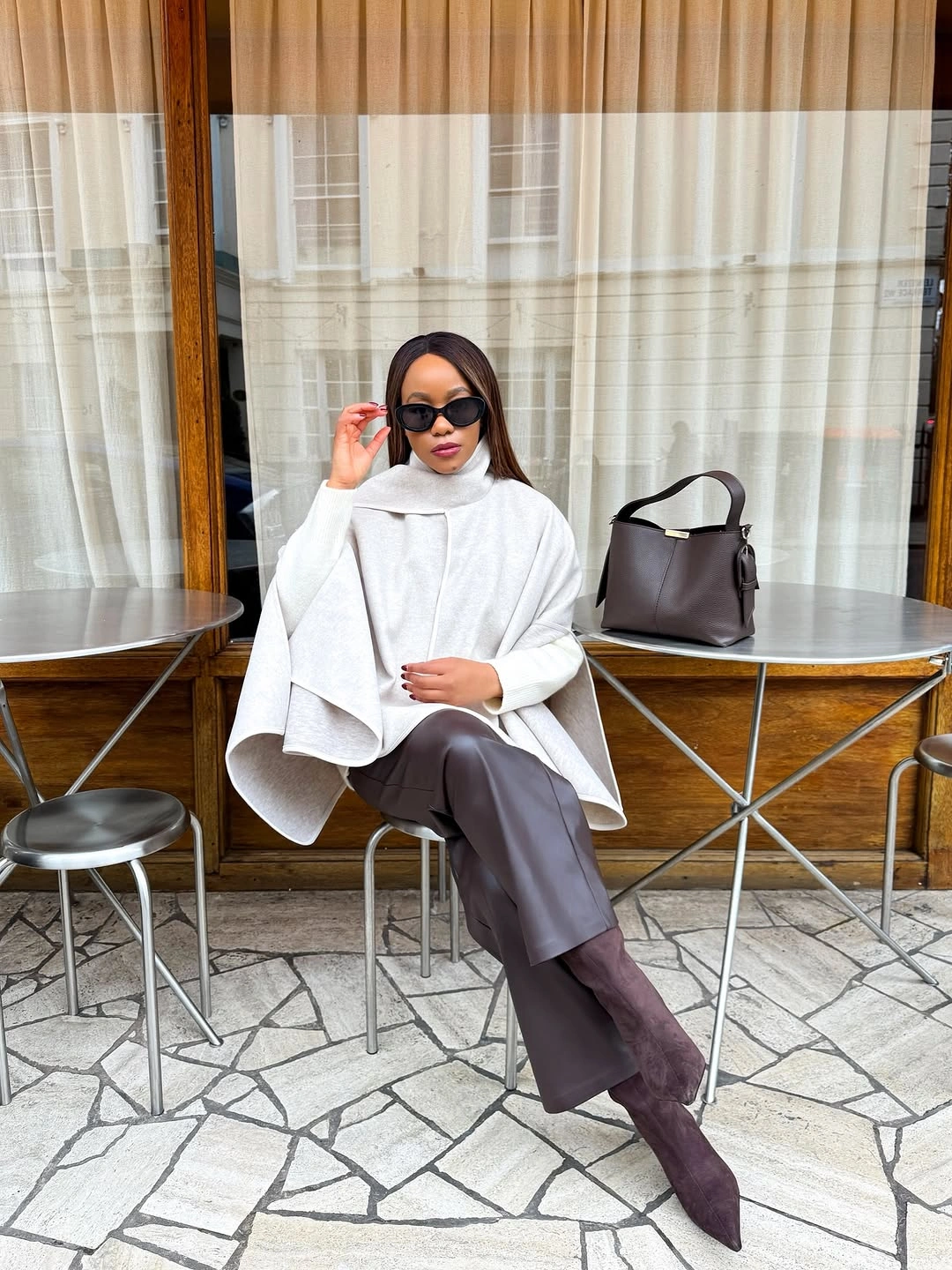 White draped high neck knit brown wide trousers pointed dark boots and bag