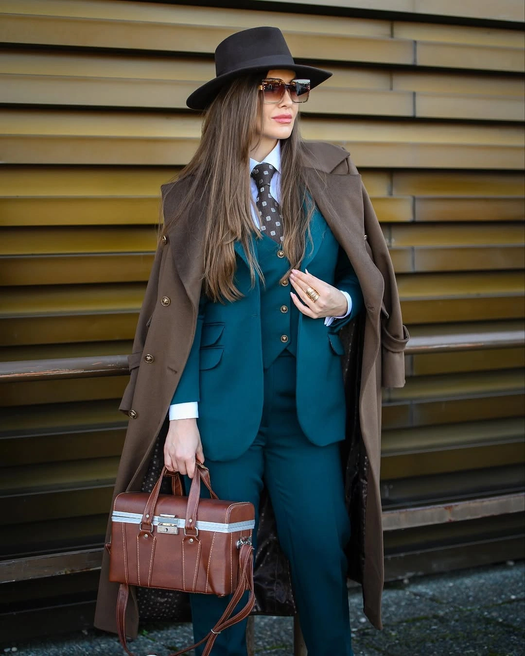 Teal suit white shirt brown long coat black hat and brown handbag