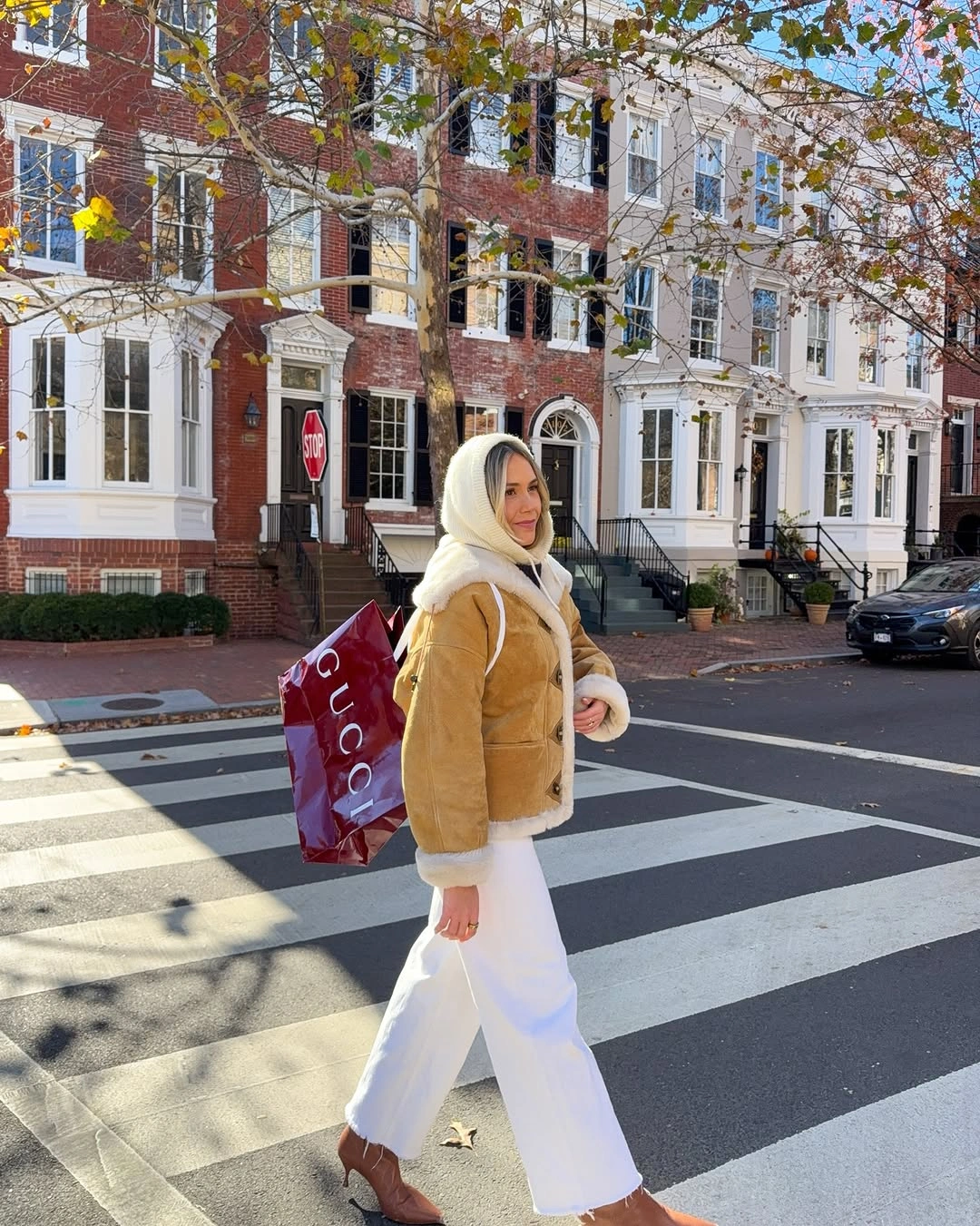 Woman in golden puffer jacket white wide leg pants and brown boots
