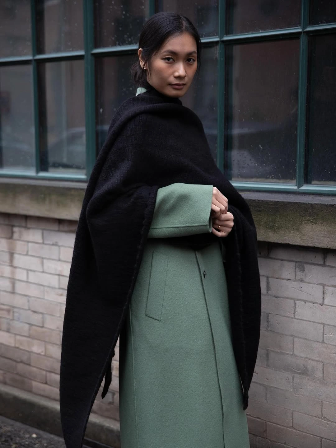Long muted green outer layer with black wrap and green handheld bag