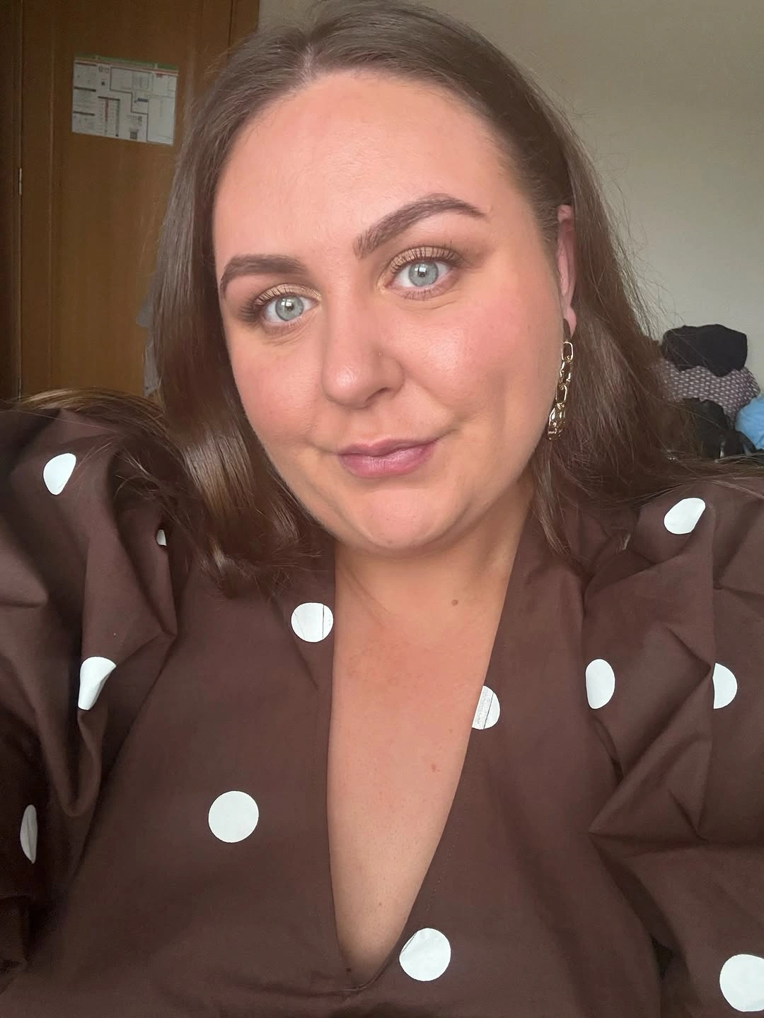 Medium brown hair with curled ends and polka-dot blouse
