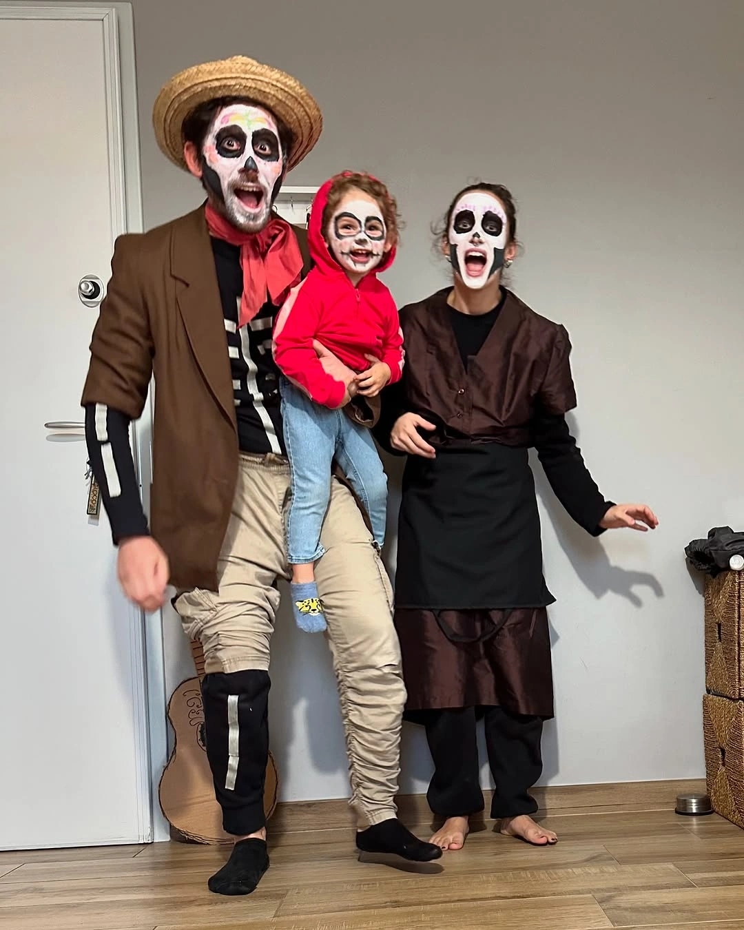 Skull face paint family Halloween costumes with straw hats and red accents
