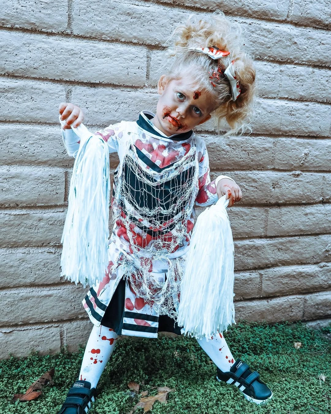White and black shredded Halloween costume with pale strips and red marks