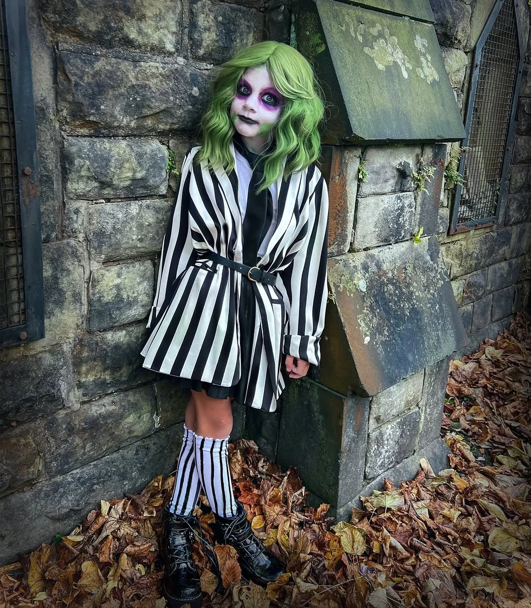 Black-and-white striped Halloween costume with green hair and black boots