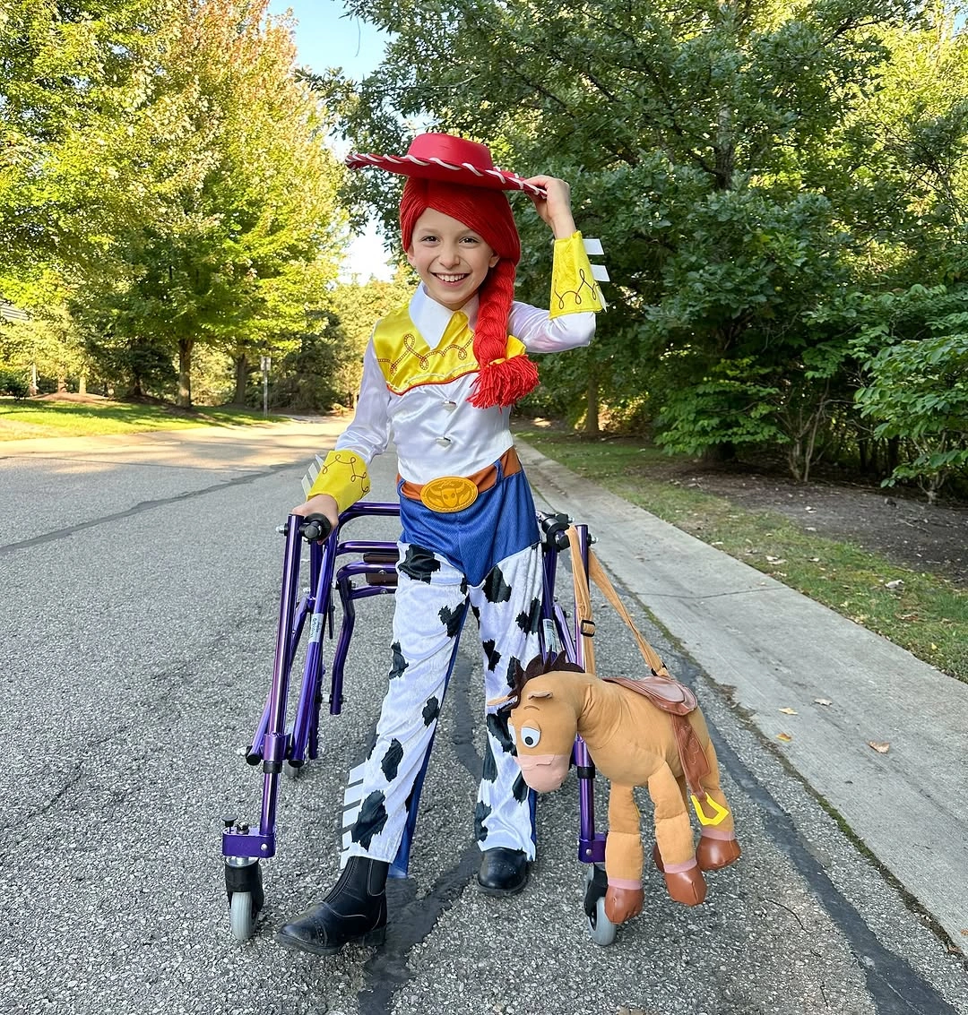 Yellow cowgirl Halloween costume with red hat and cow-print chaps
