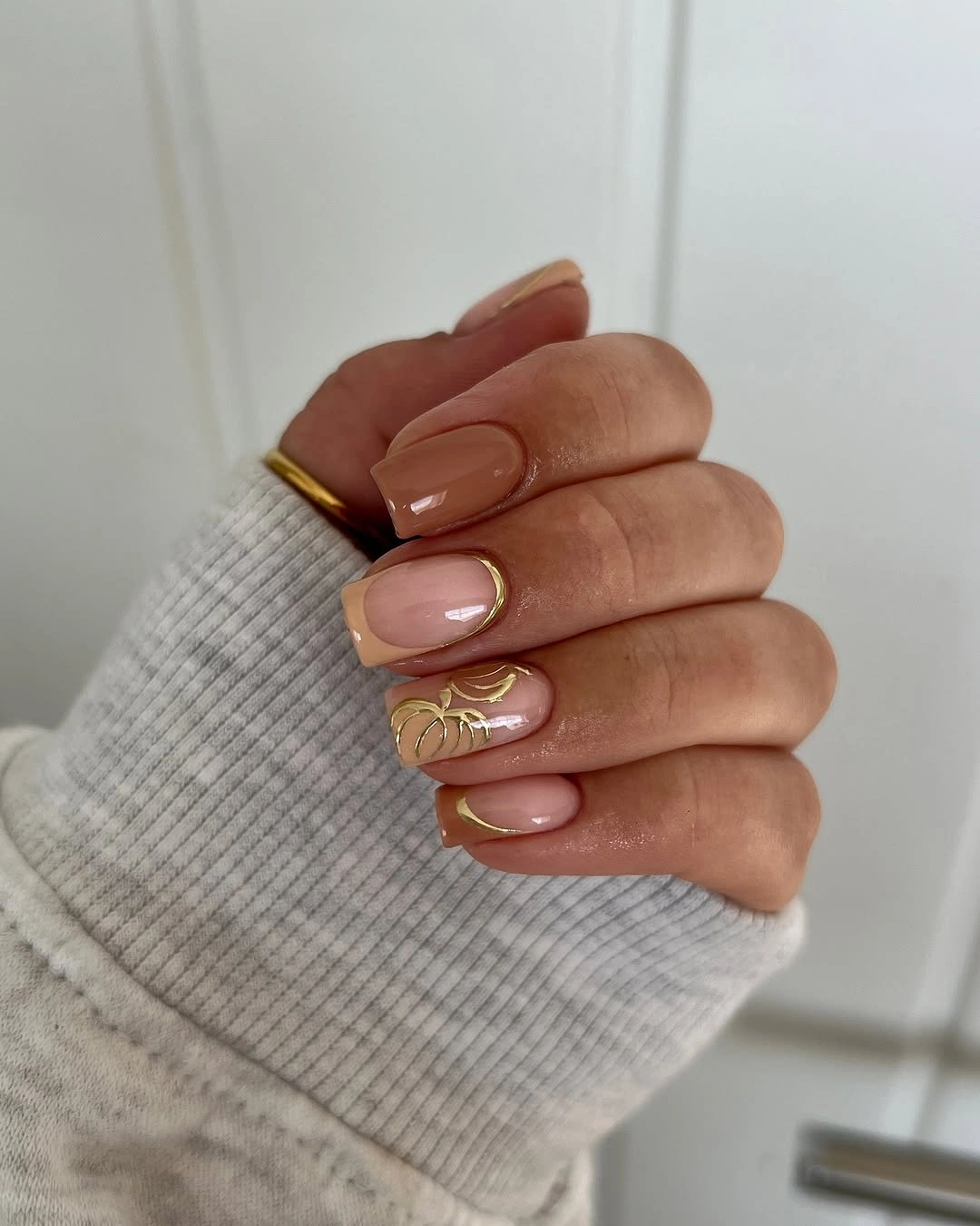 Short sheer nude nails with tiny pumpkin outline and gold accents