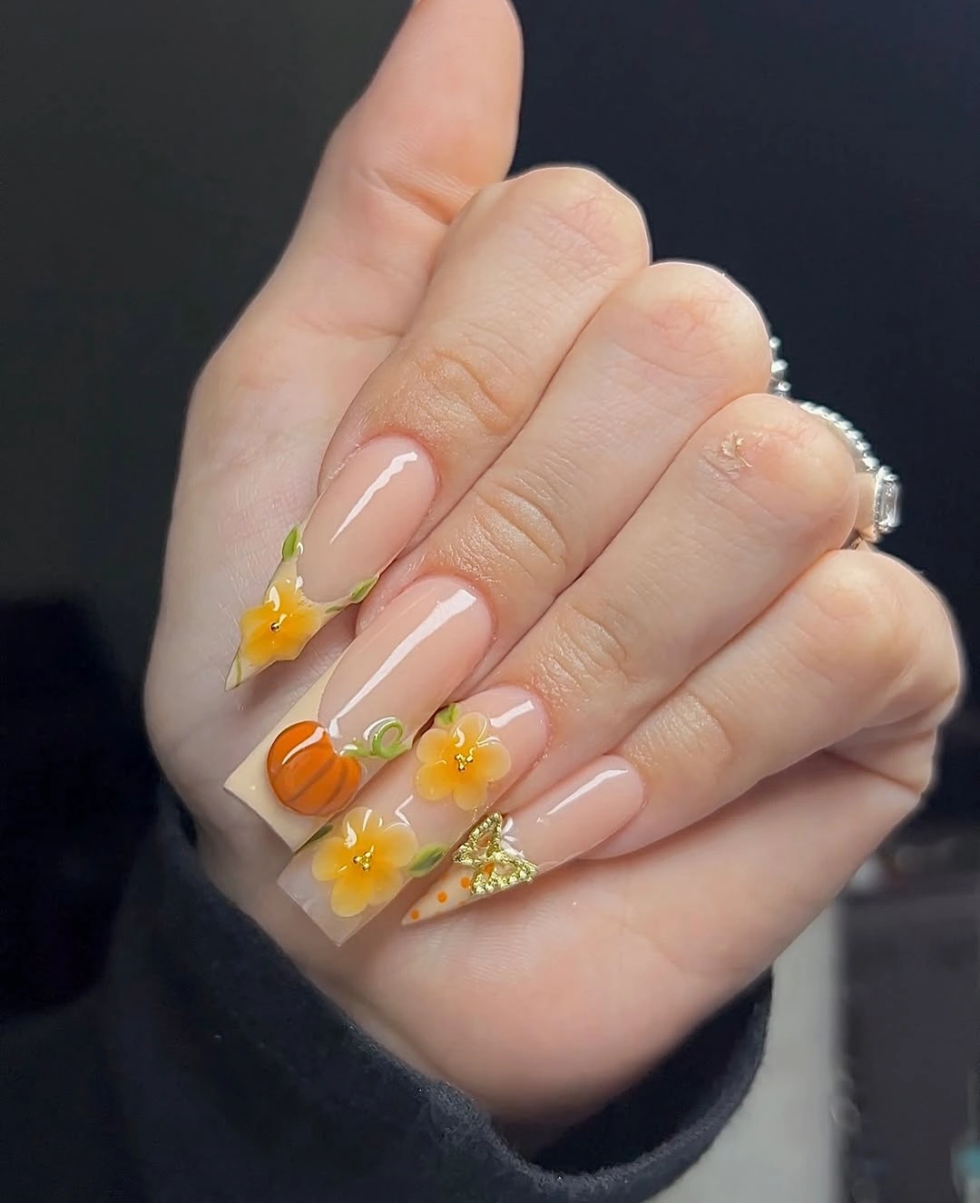 Long nude nails with small pumpkins yellow flowers and leaves