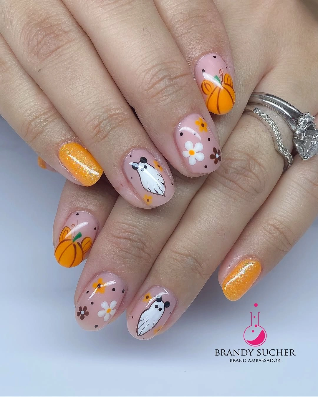 Short soft pink nails with tiny ghosts pumpkins and flowers