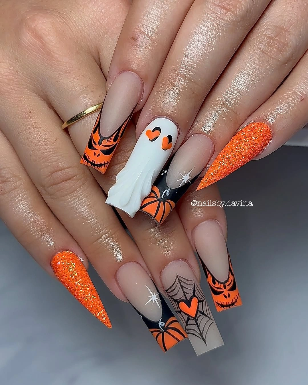 Pointed orange Halloween nails with ghost pumpkins and spiderwebs