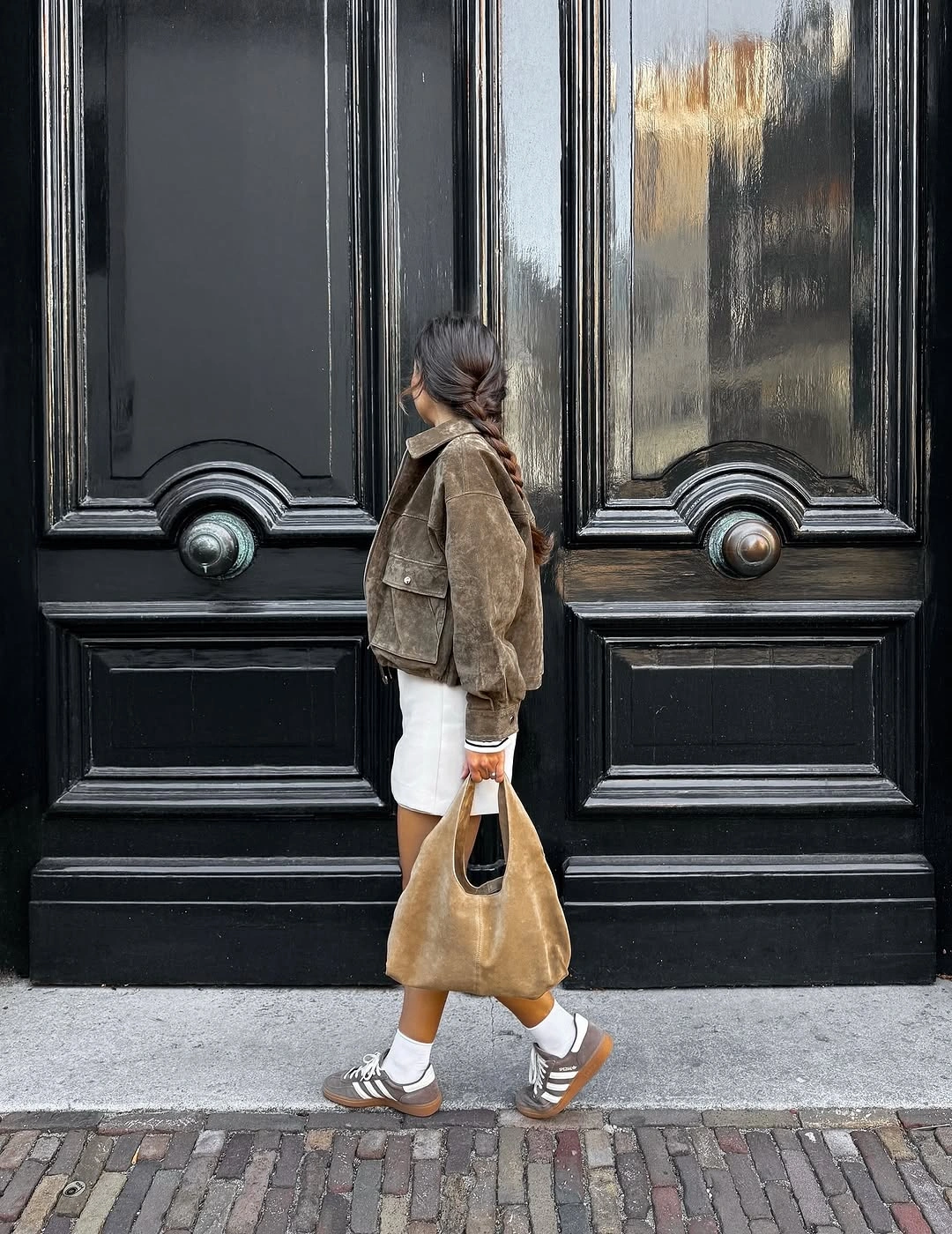 Rust-brown jacket with white trim and black wide trousers